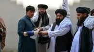 طالبان در حال توزیع دلار بین مردم+ عکس